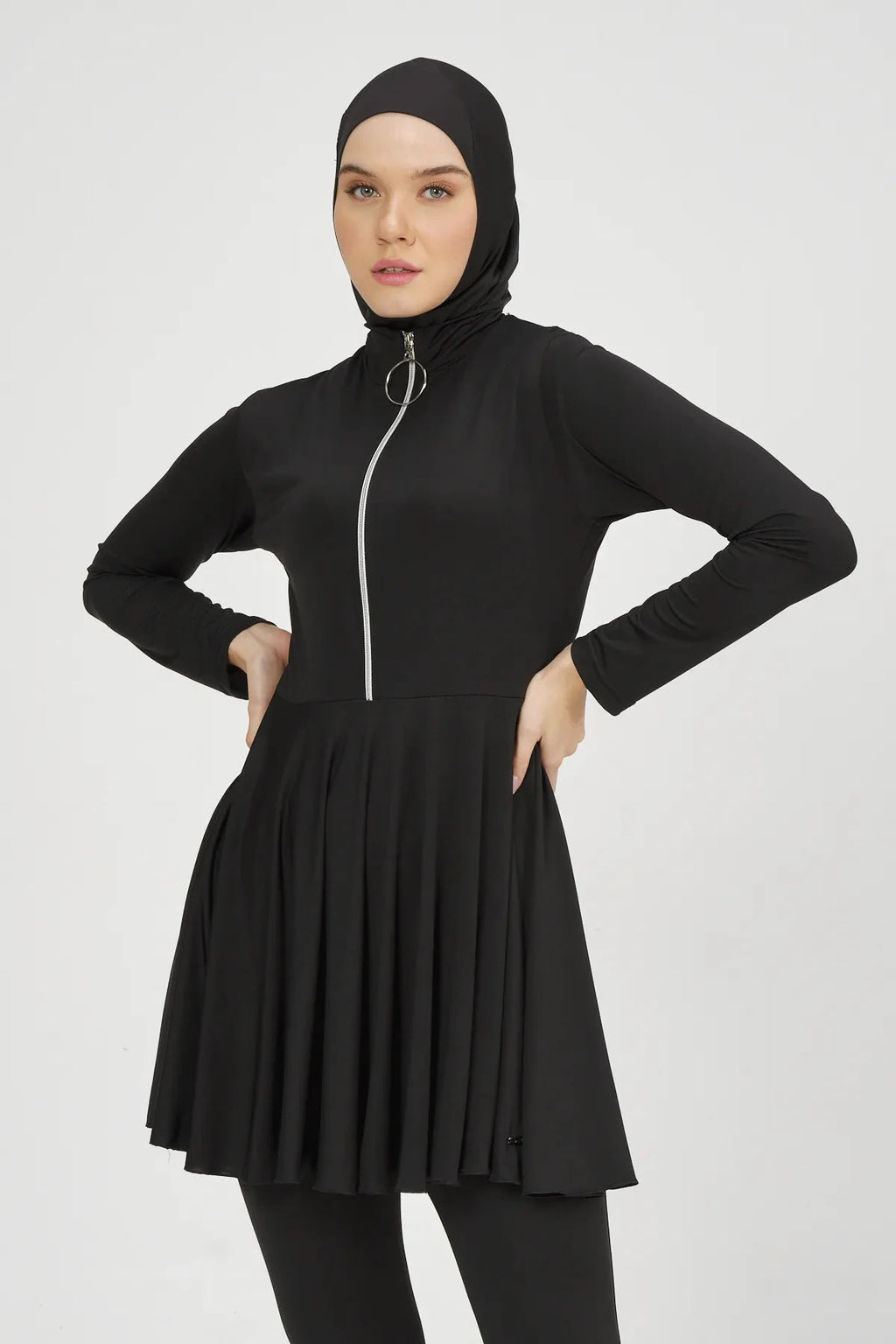 Close-up of black flared modest swimsuit top and hijab on model