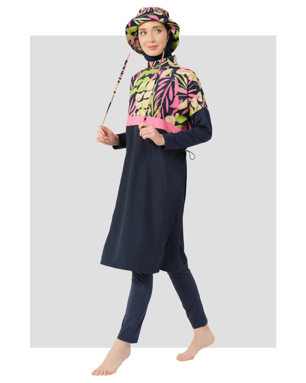 Woman in navy tropical print burkini set with matching bucket hat.