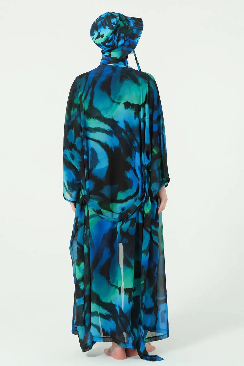 Model in full burkini set with sheer kimono and bucket hat, back view.