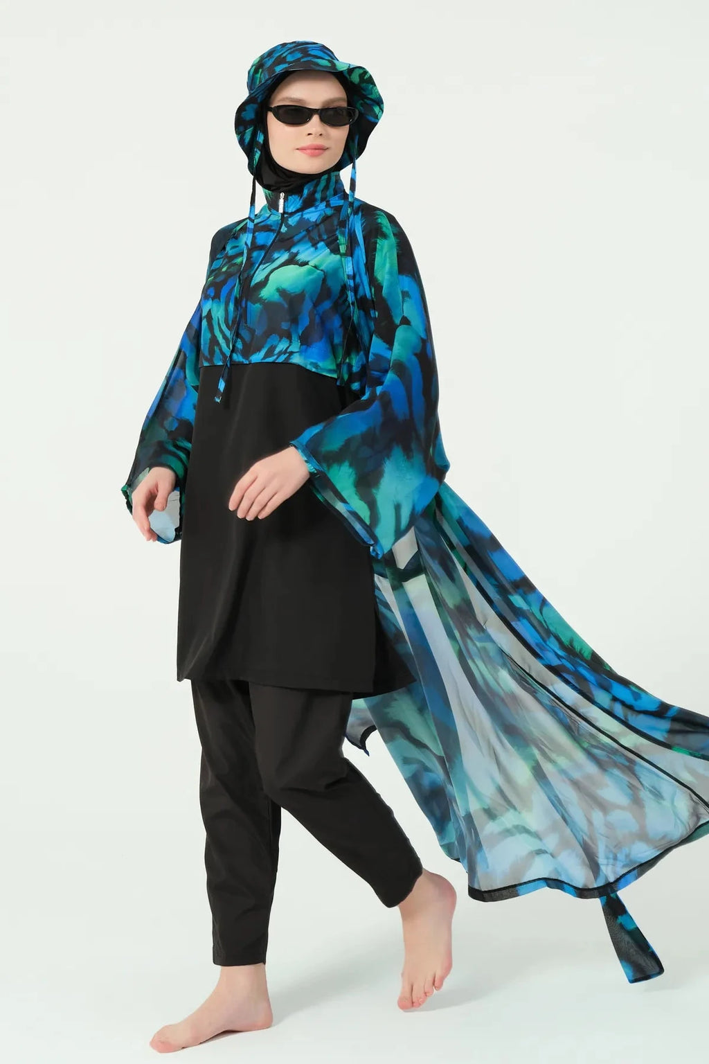 Model walking in burkini set with flowing sheer kimono, side view.
