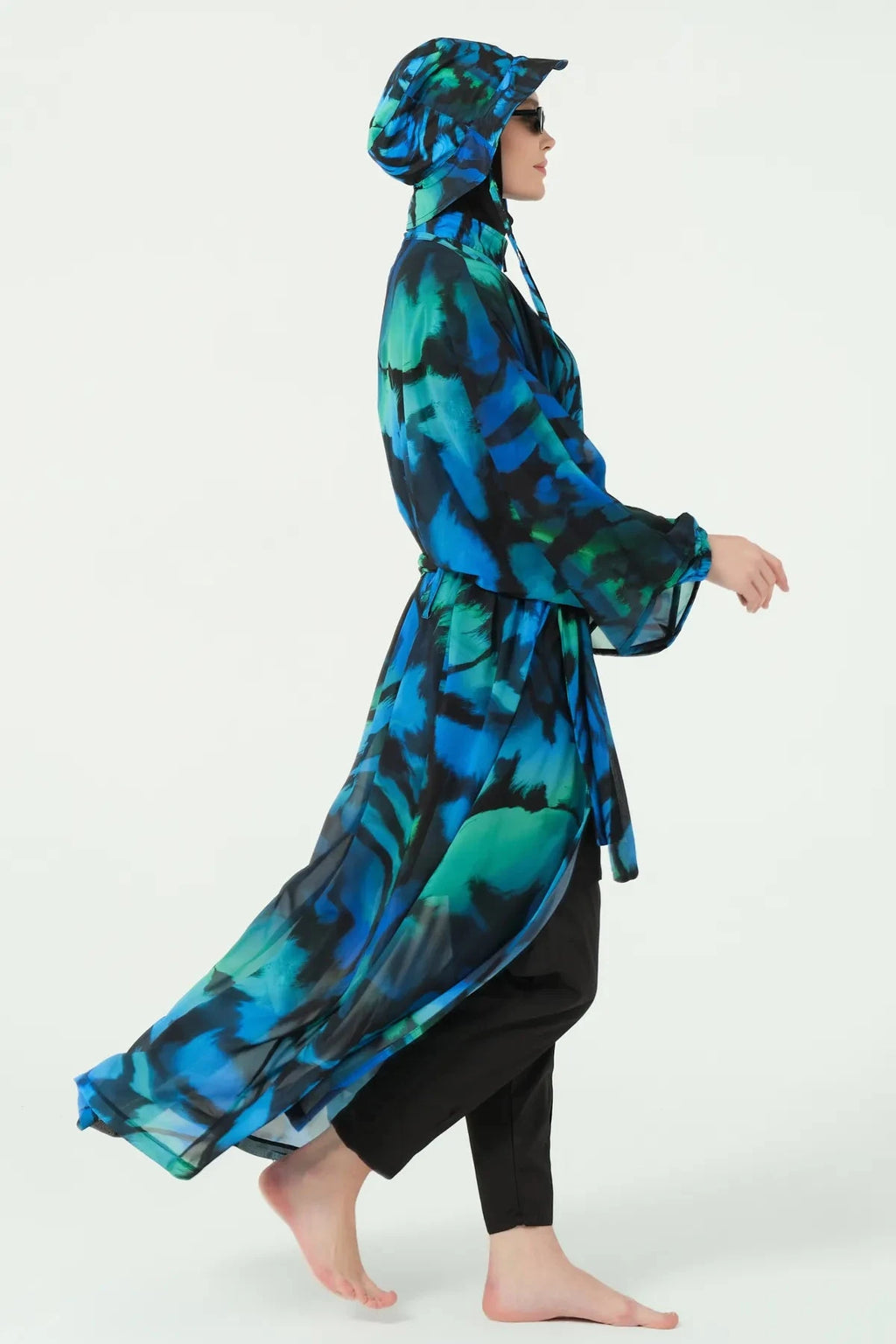 Model in burkini set with sheer kimono flowing, profile view.