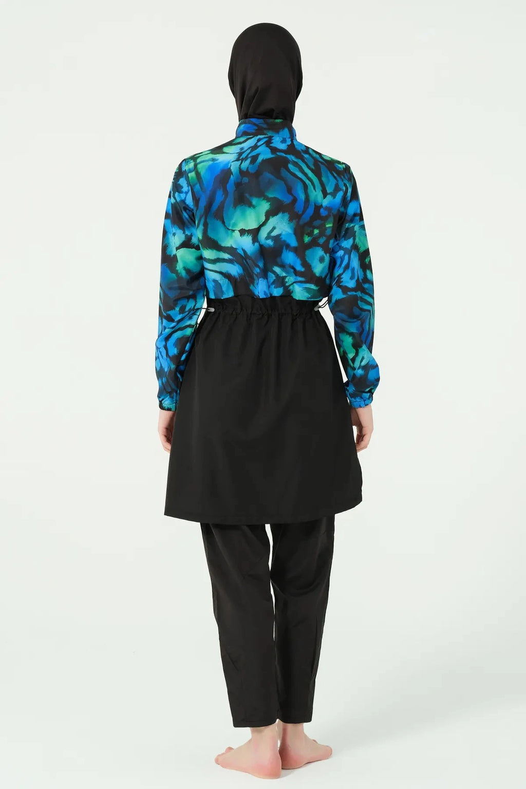 Model wearing burkini tunic, jogger pants, and black hijab, back view.