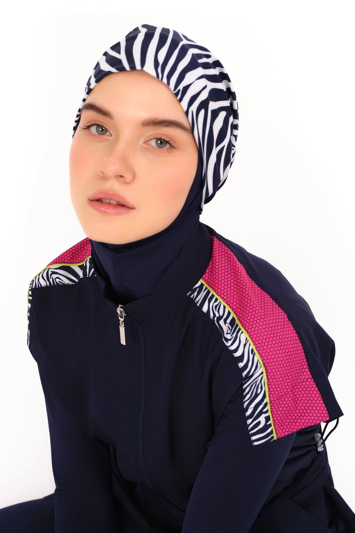 Close-up of navy burkini top with zebra print hijab and pink detail.