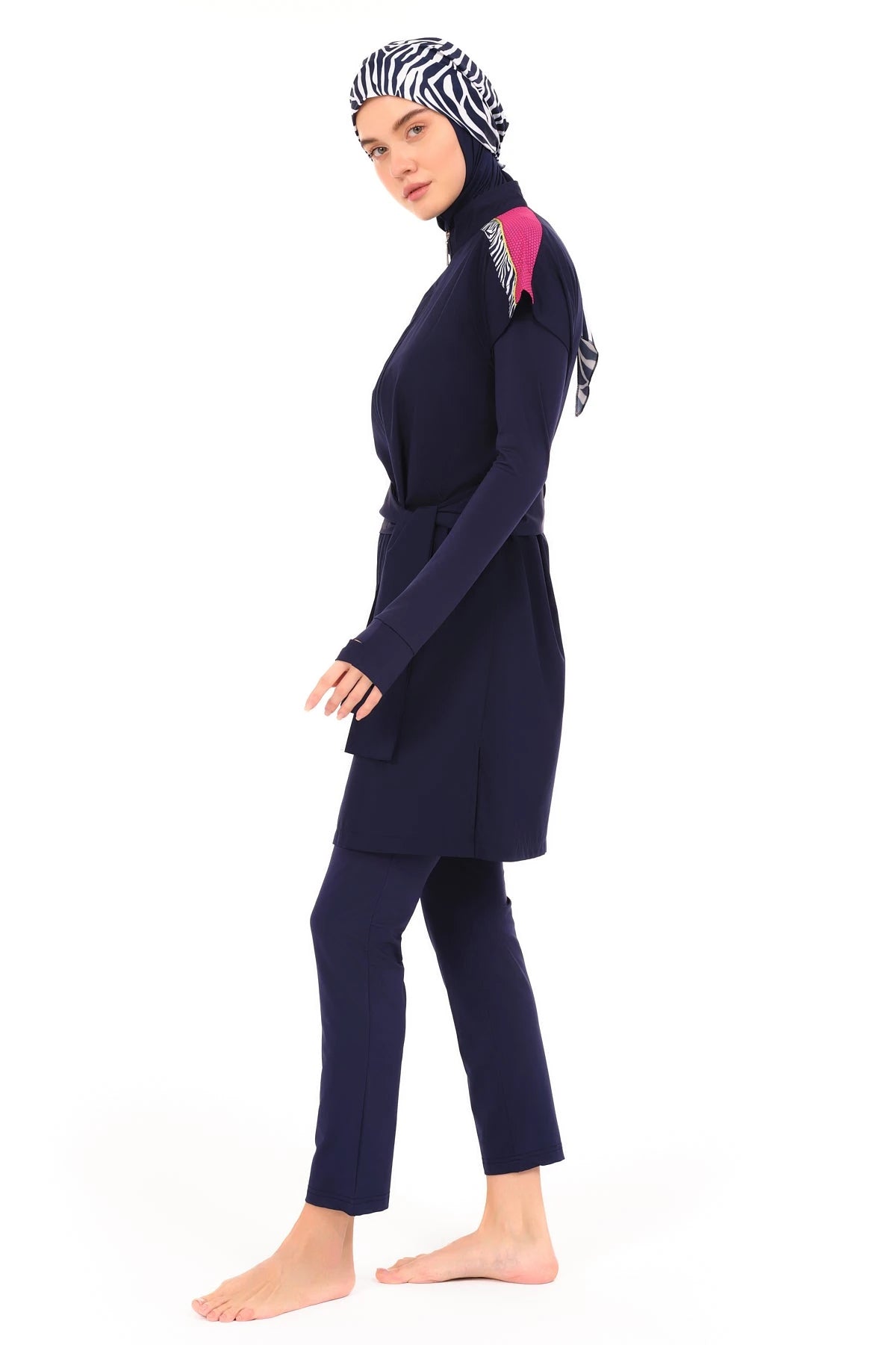 Model in navy burkini set with zebra print hijab, side view.