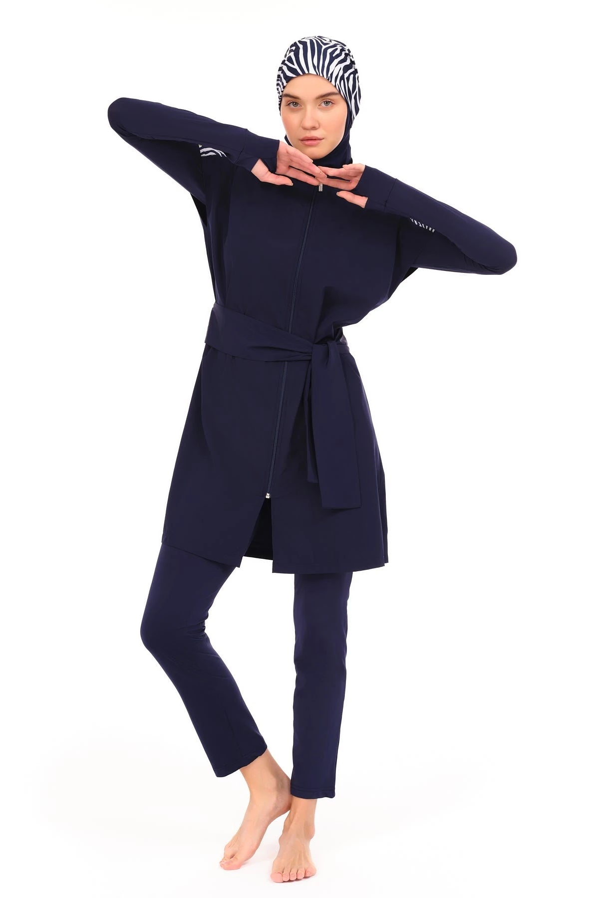 Model in navy burkini set with zebra print hijab, posing.