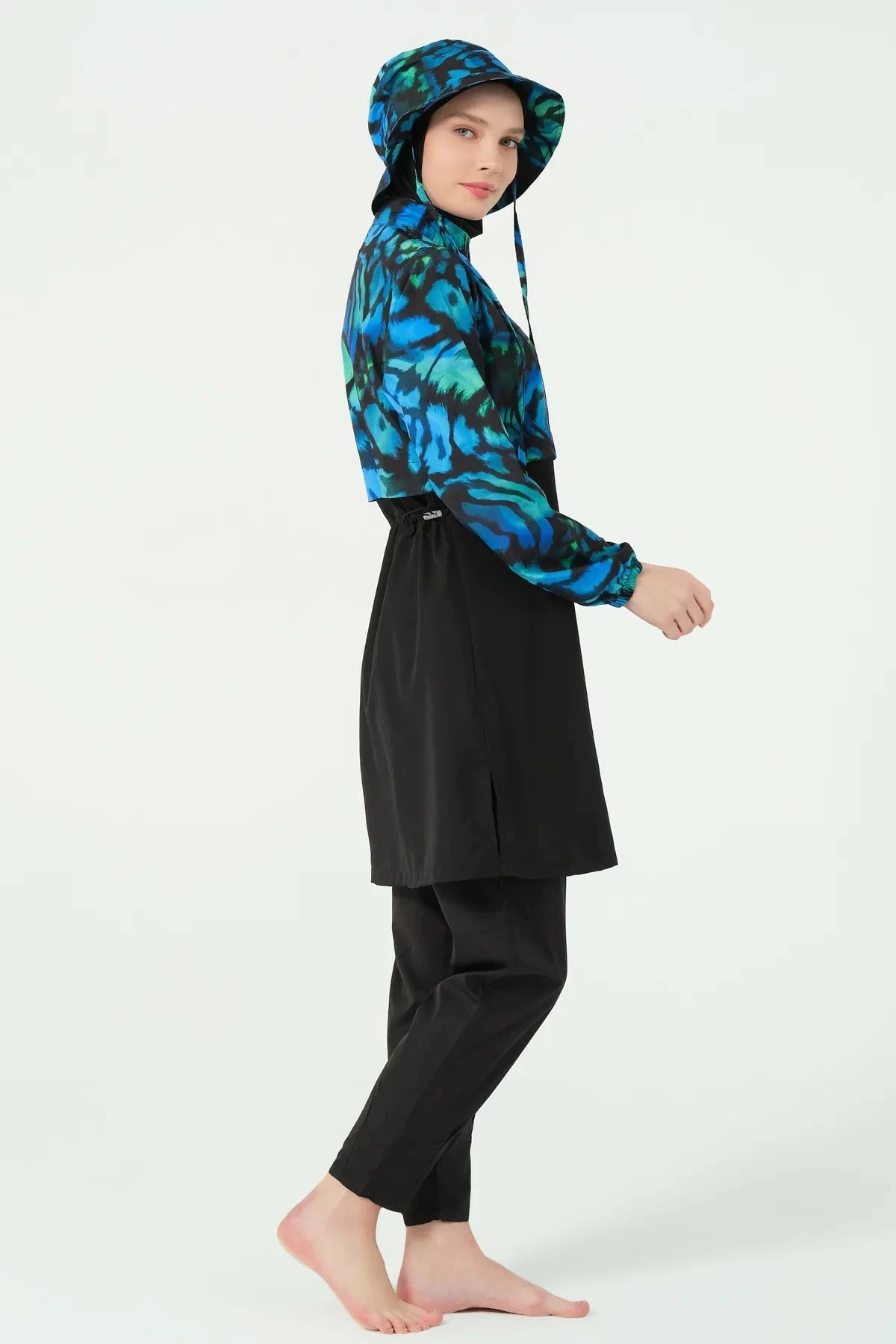 Side profile of woman in full coverage ocean print modest swimwear.