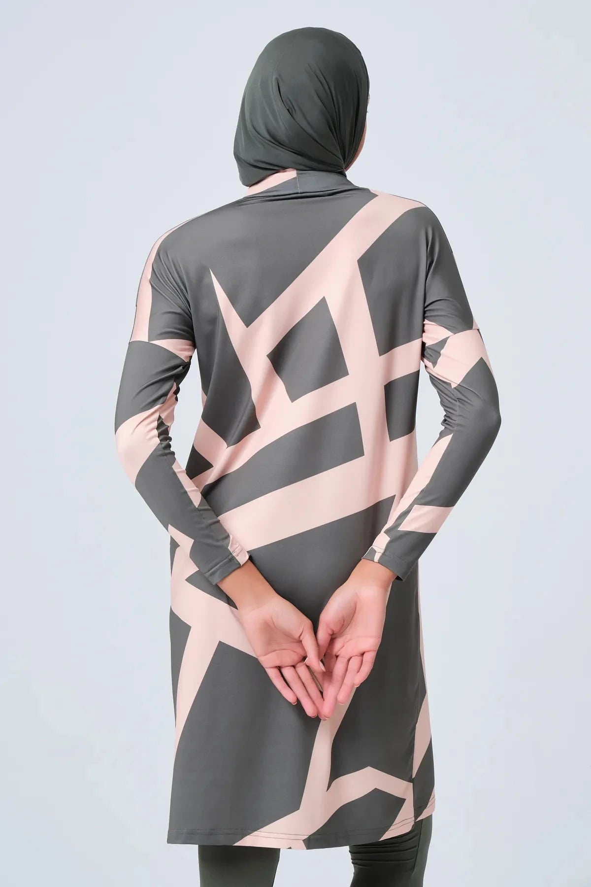 Grey and pink geometric print burkini set with hijab hands clasped behind back