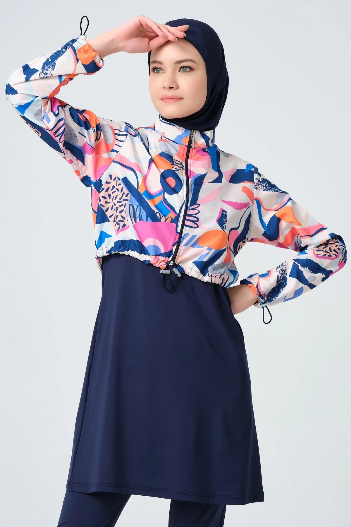 Close-up of woman in vibrant abstract print hijab swimwear.