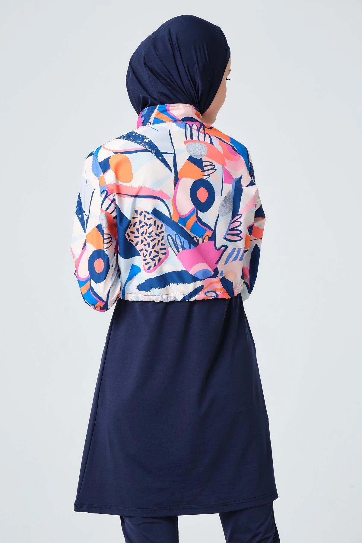 Back view detail of woman in vibrant abstract print hijab swimwear.