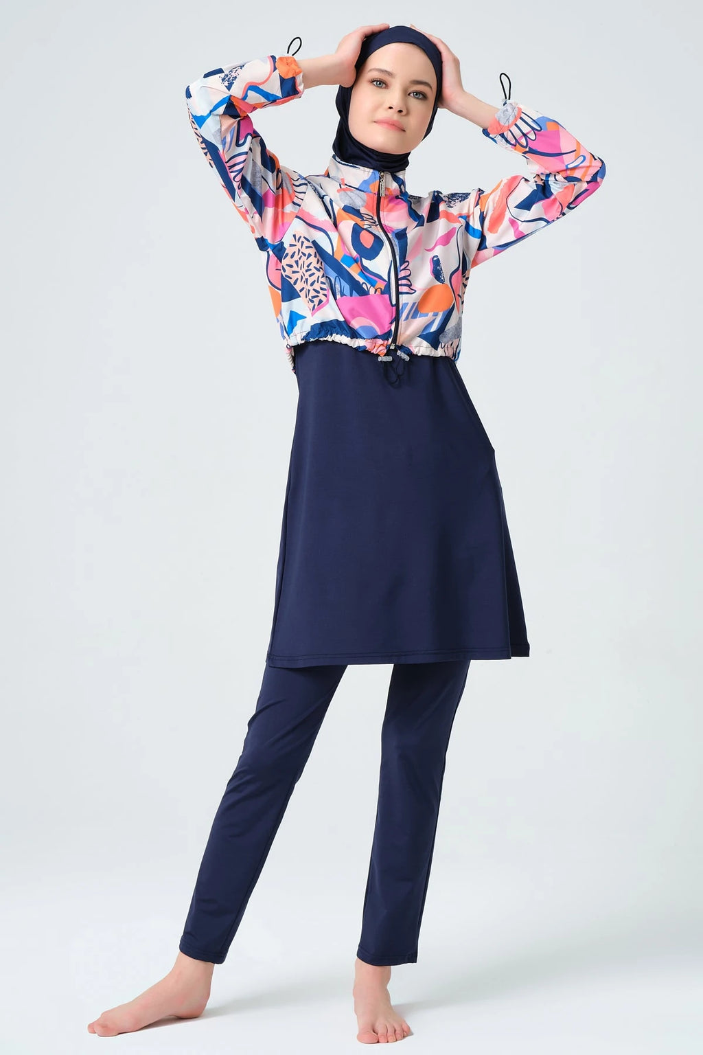 Woman in vibrant abstract print hijab swimwear set full pose.
