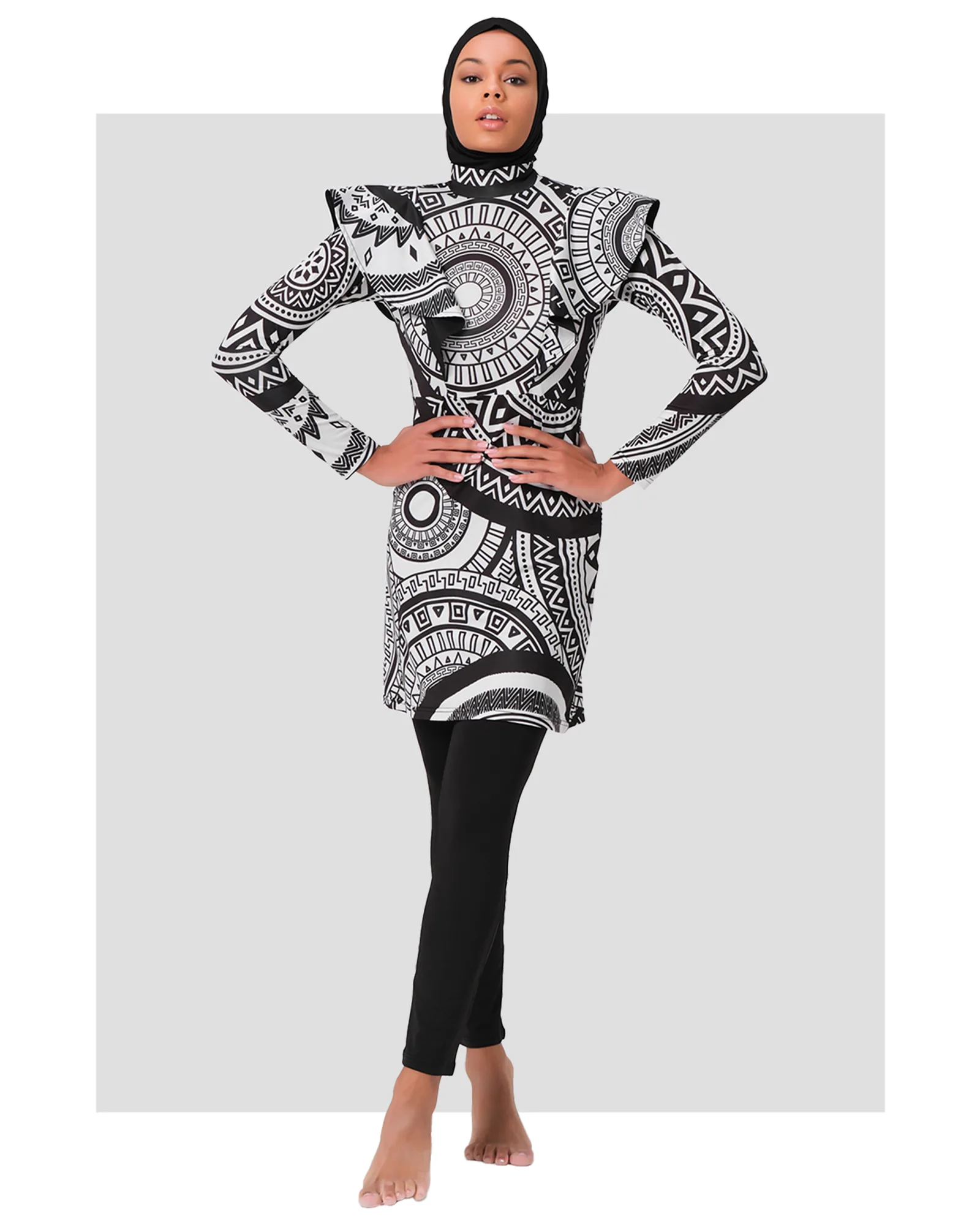 Woman in black and white tribal print burkini set, front view.