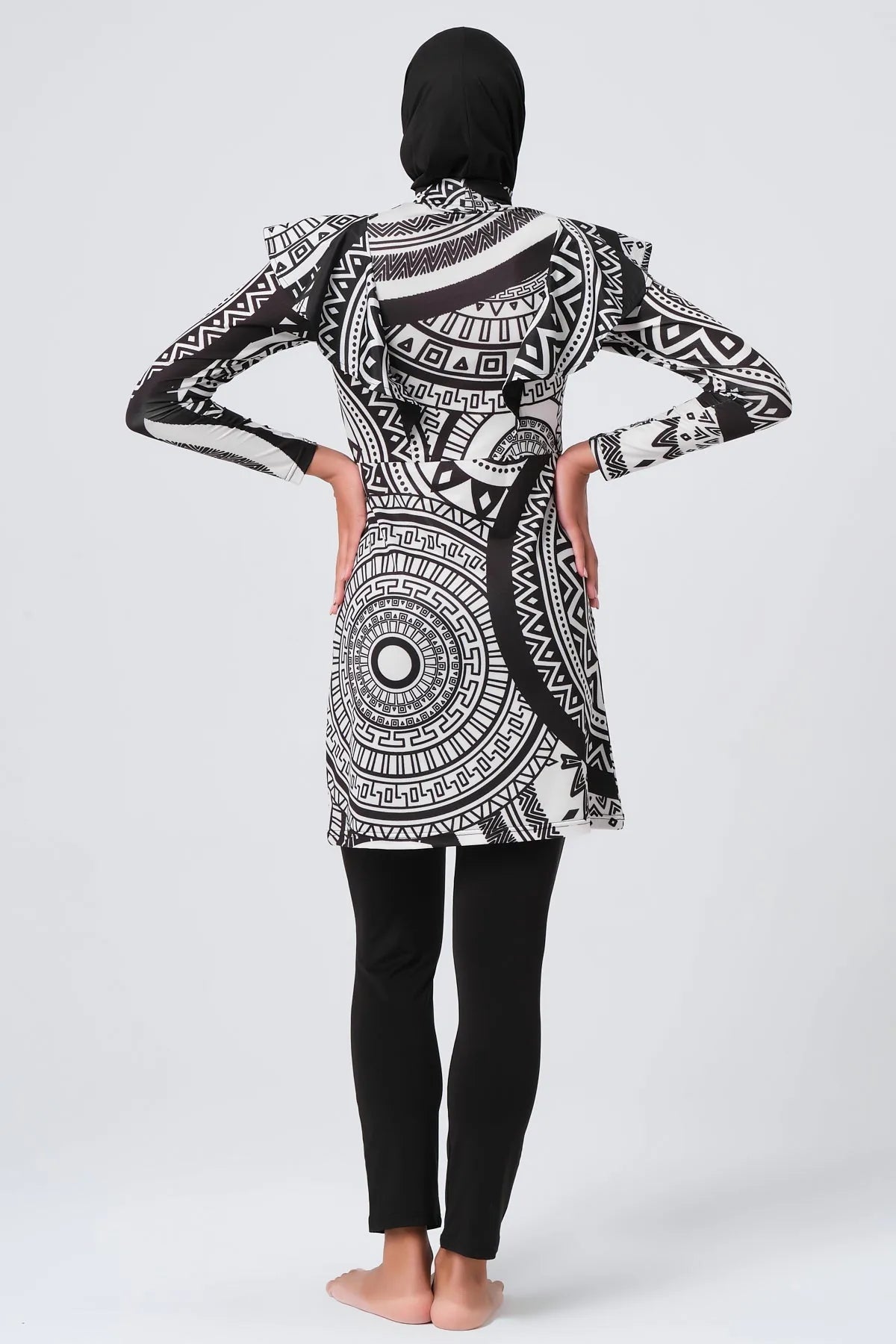 Woman in black and white tribal print burkini set, back view.