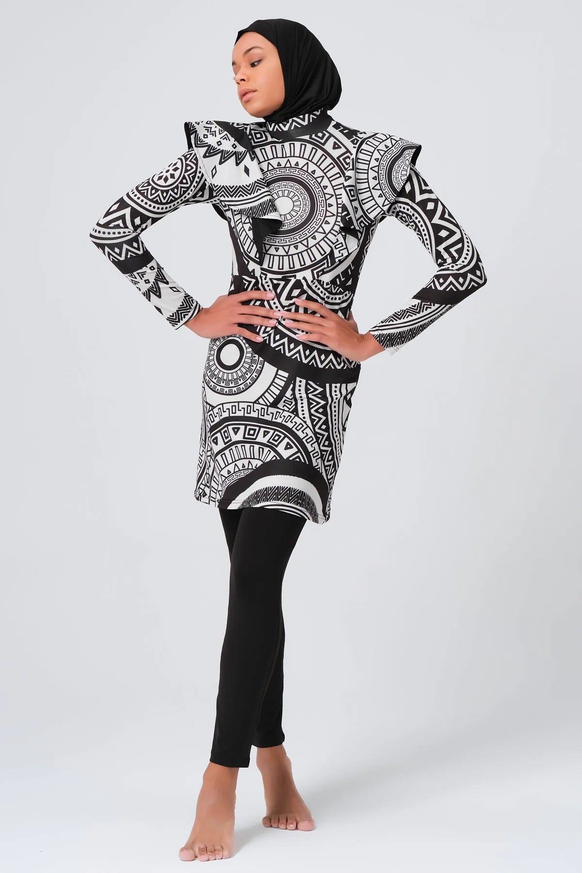 Full length view of woman wearing black and white tribal print burkini.