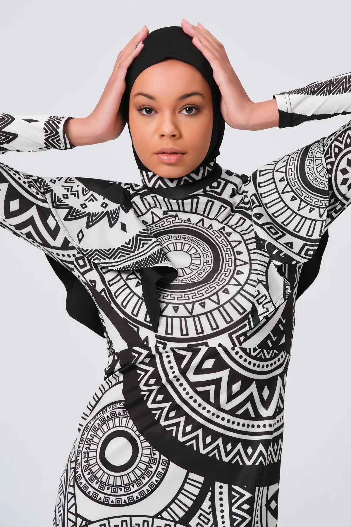 Close-up of woman's face and upper burkini with tribal print.