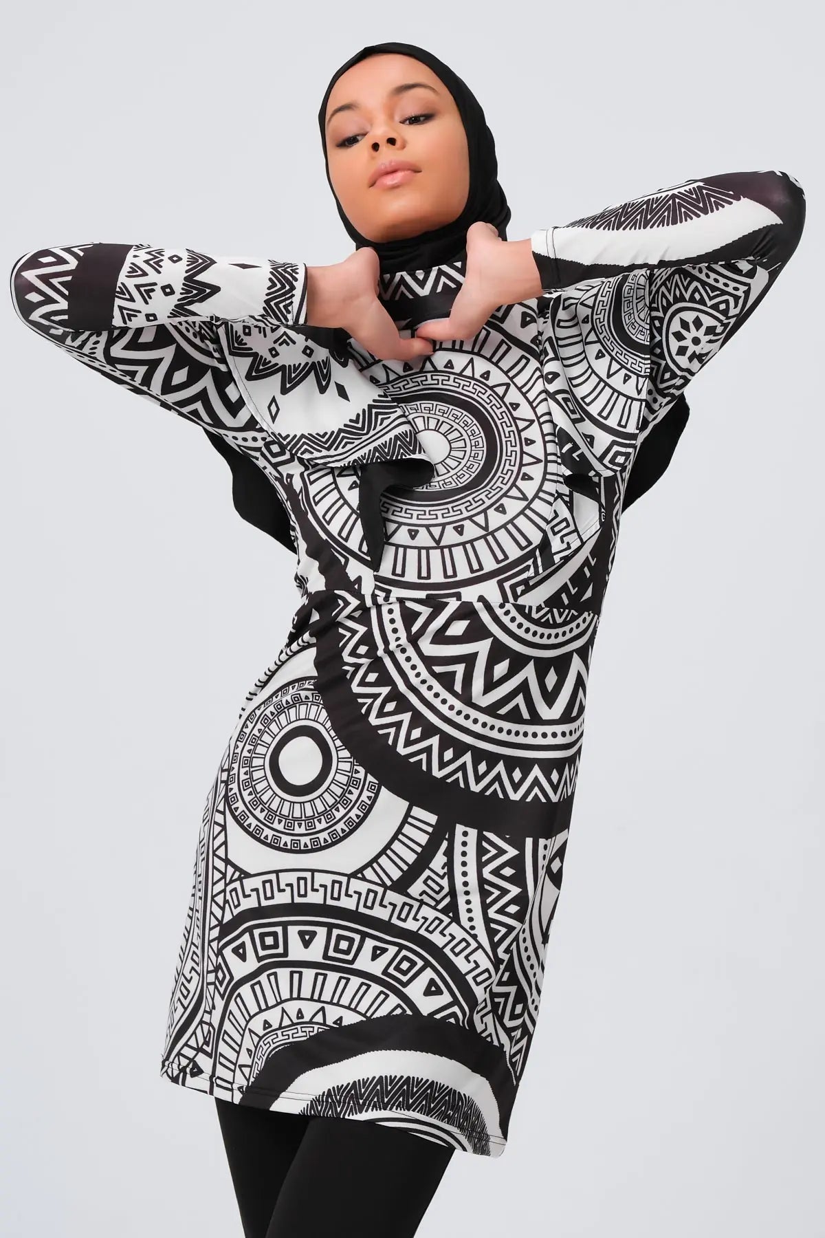 Woman in black and white tribal print burkini, upper body view.