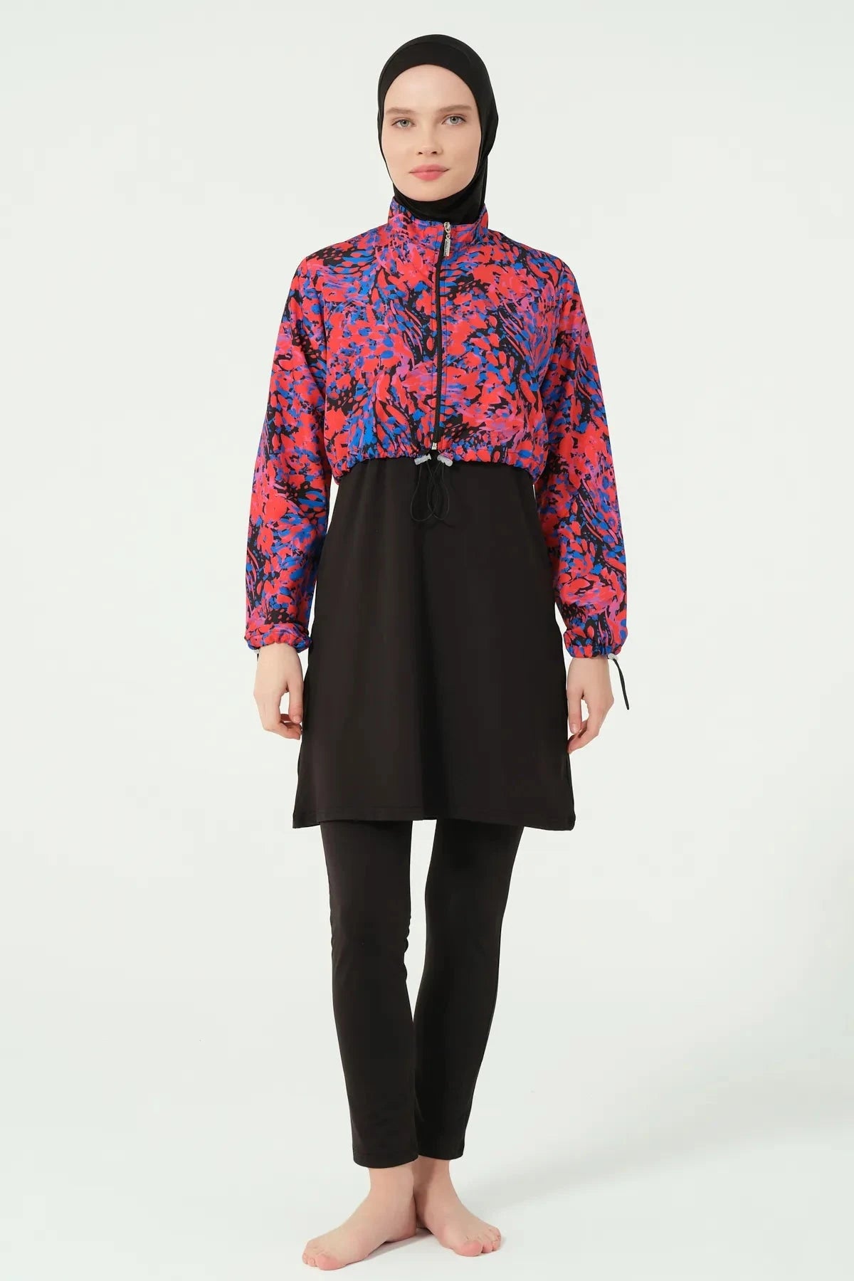 Woman in black hijab swimwear with abstract print jacket, full front view.