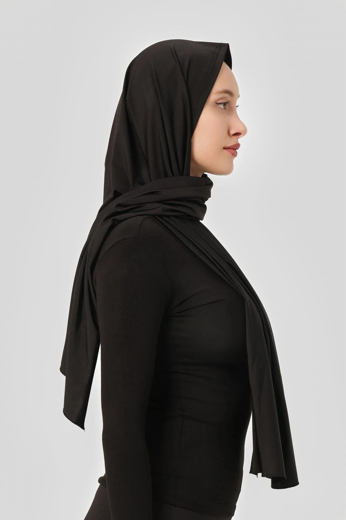Profile view of a black swim hijab with a secure fit.
