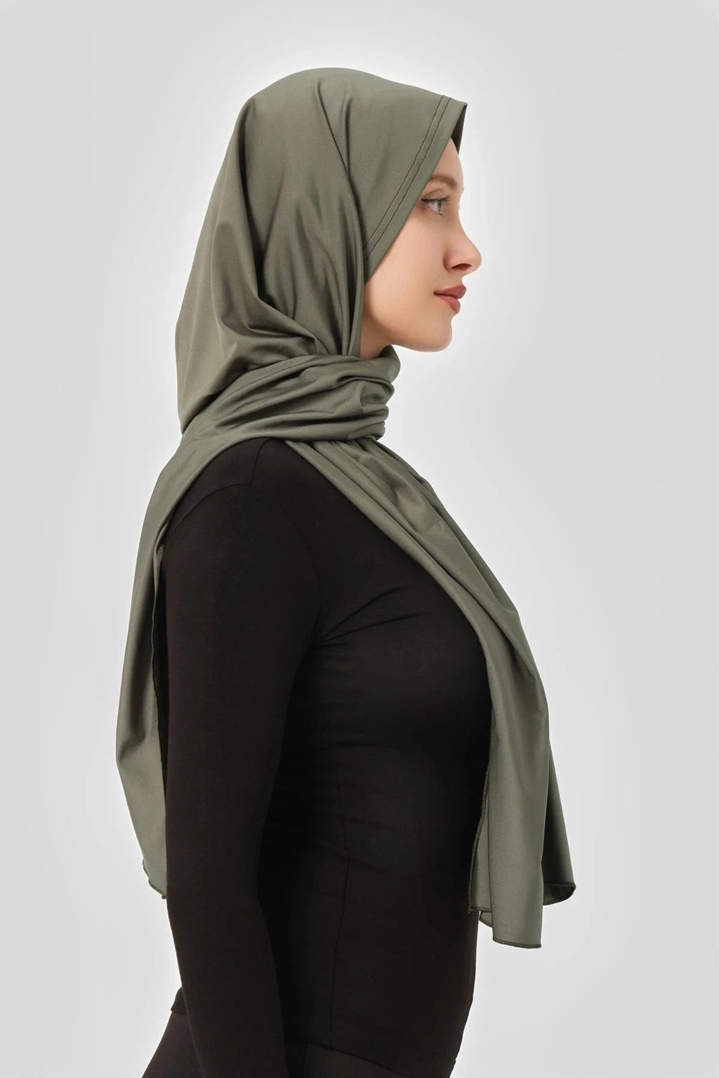 Olive green swim hijab in profile view, draped elegantly.