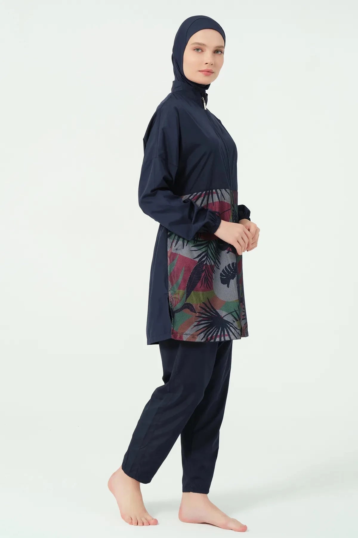 Navy burkini set with geometric print top, side view, model looking right.
