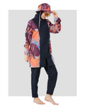 Woman in tropical print modest swimwear and bucket hat, side pose.