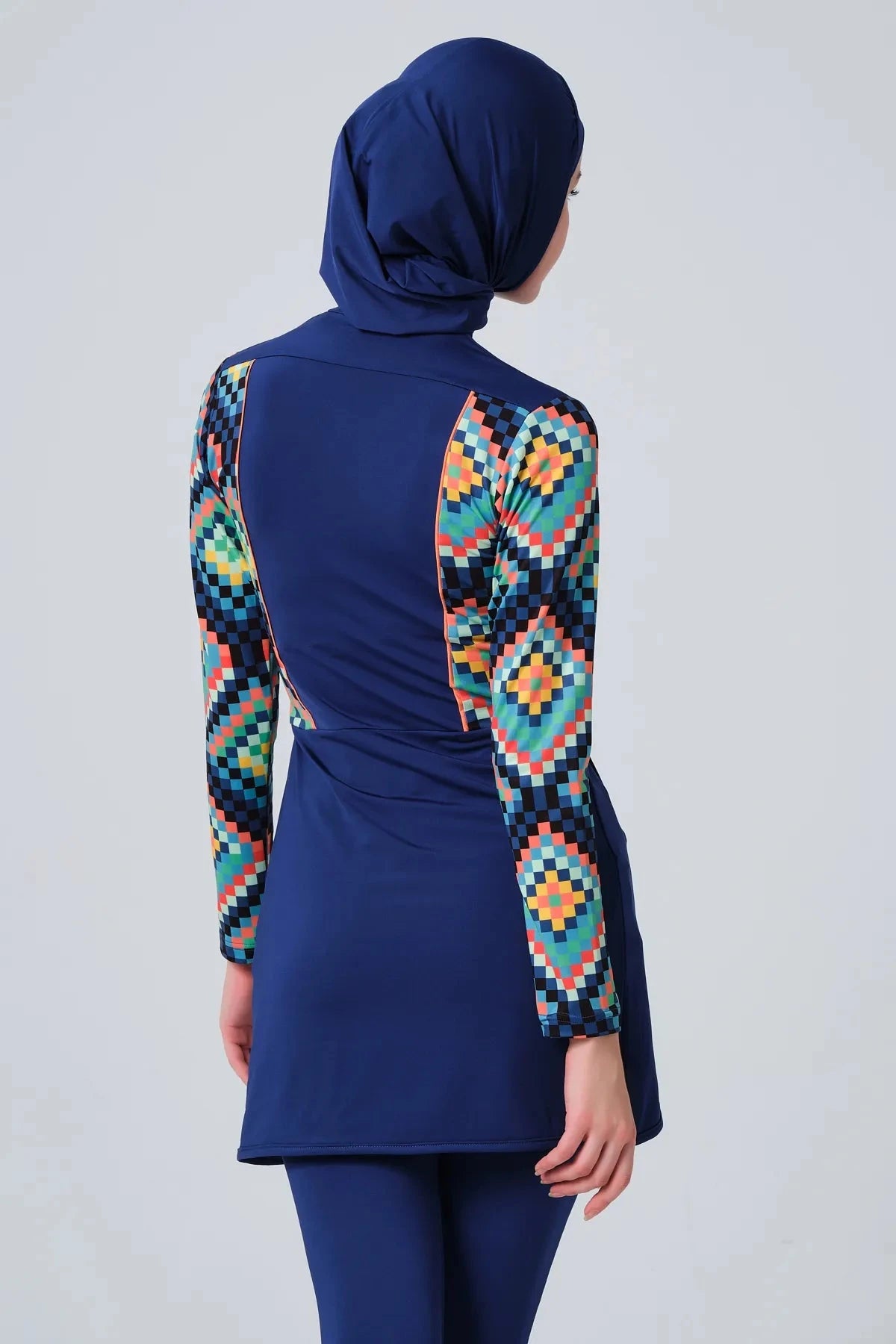 Model in blue mosaic sporty burkini back view with arms raised