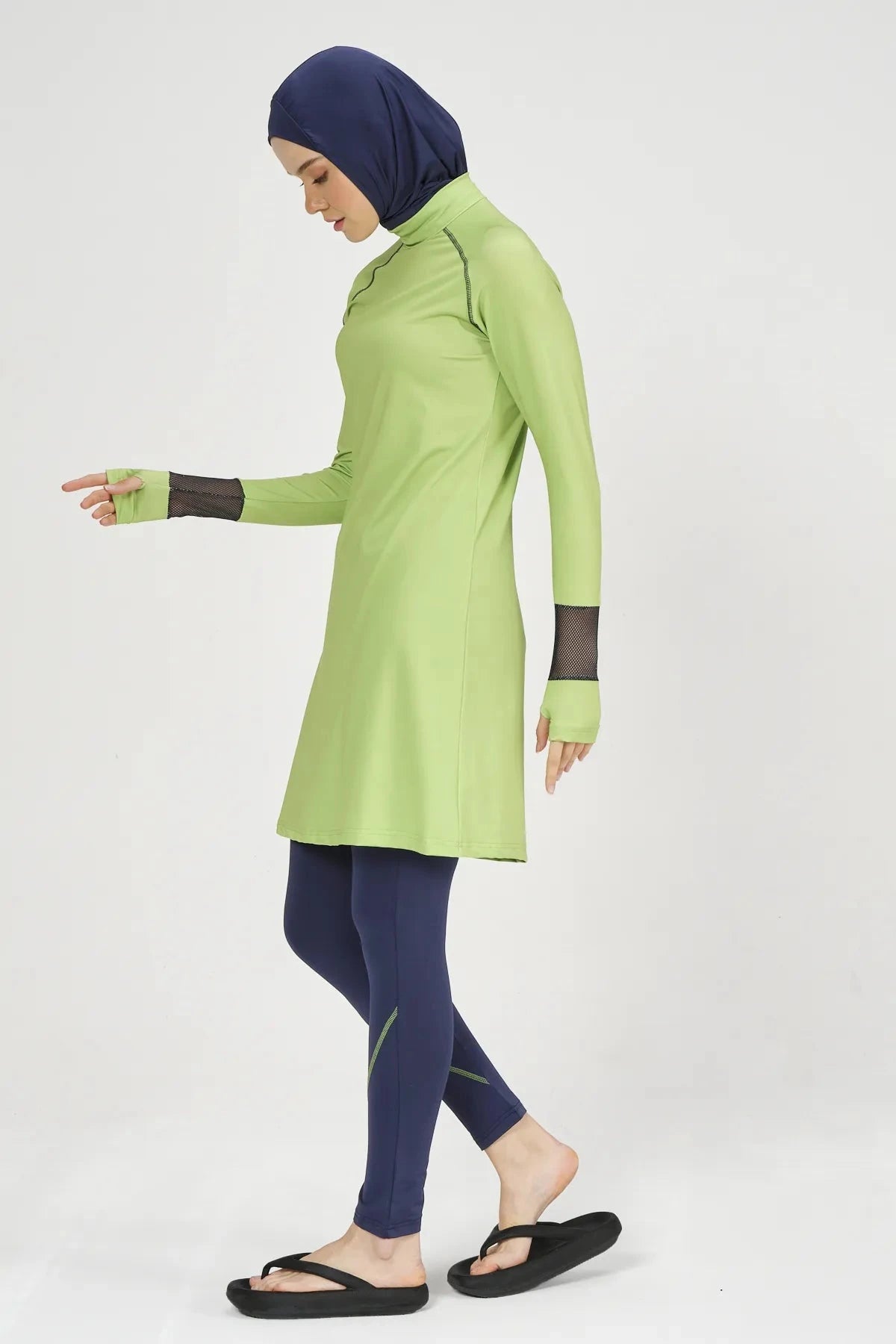 Model in lime green and navy hijab swimwear set, side view.