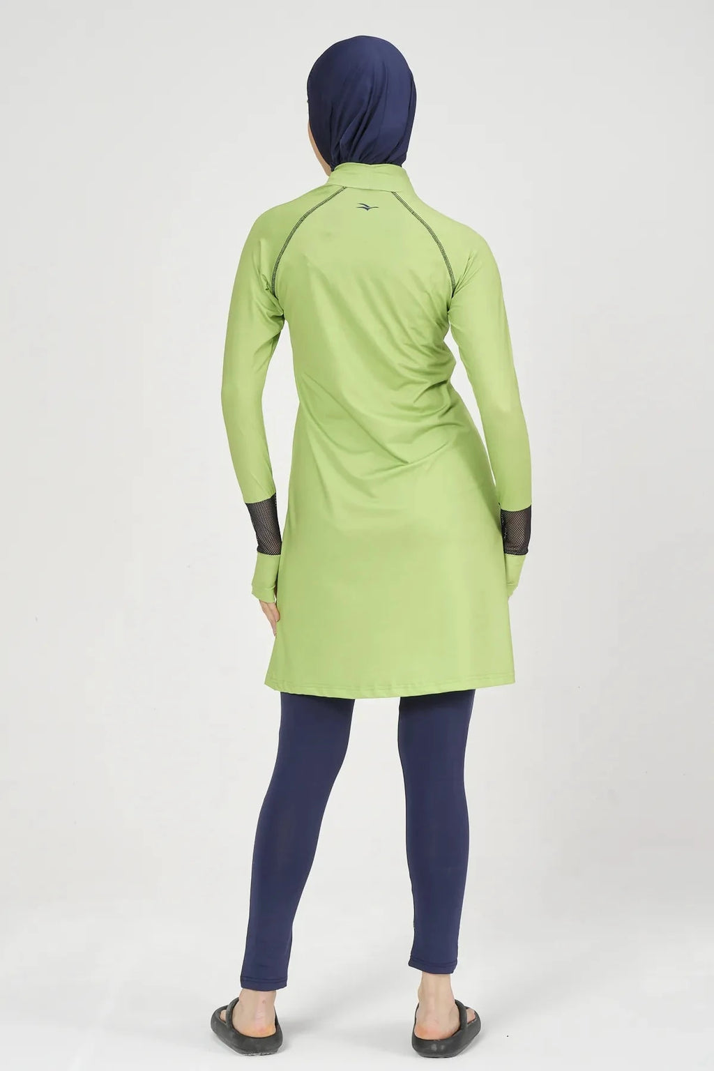 Model in lime green and navy hijab swimwear set, back view.