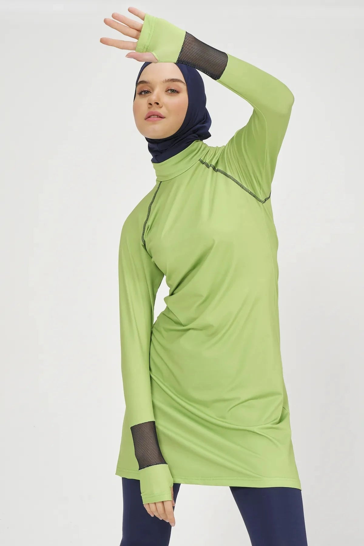 Model in lime green and navy hijab swimwear, side close-up.