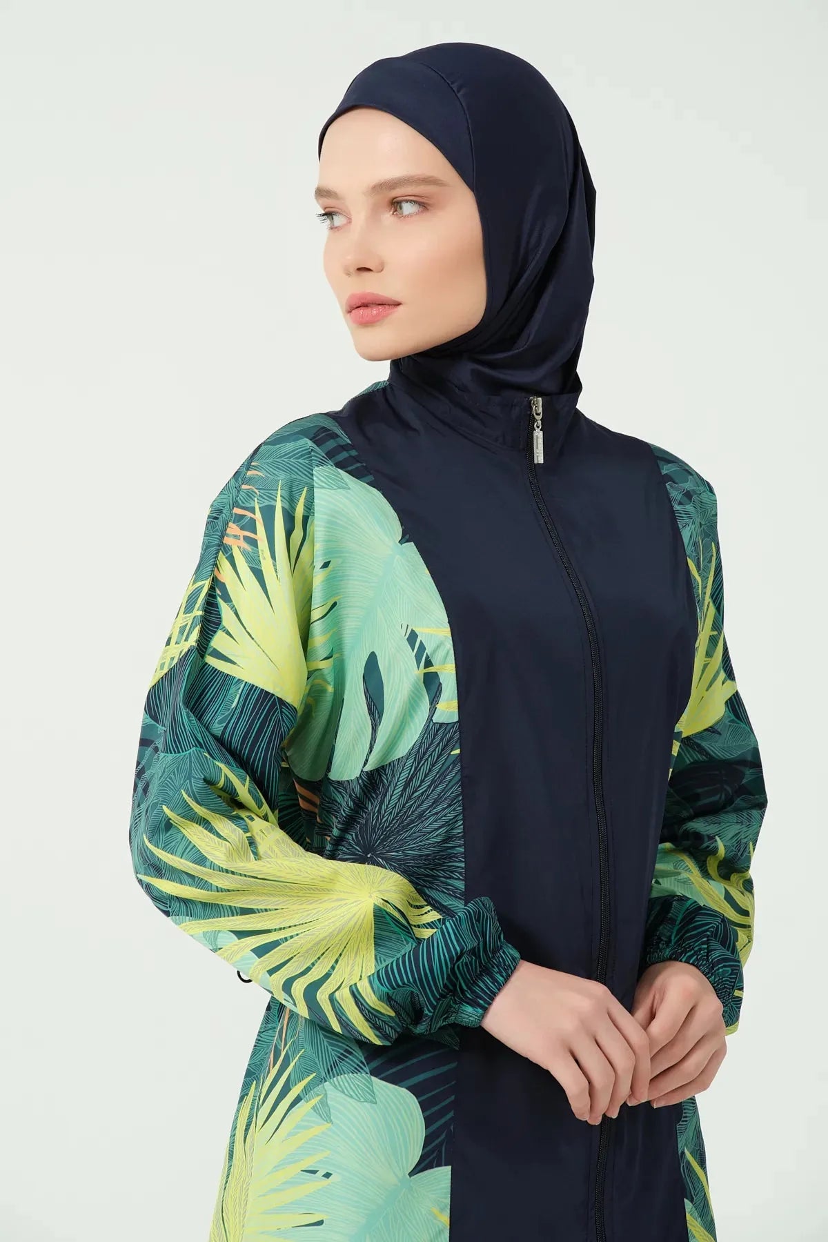 Close-up of tropical green burkini top with zip and elastic cuff.