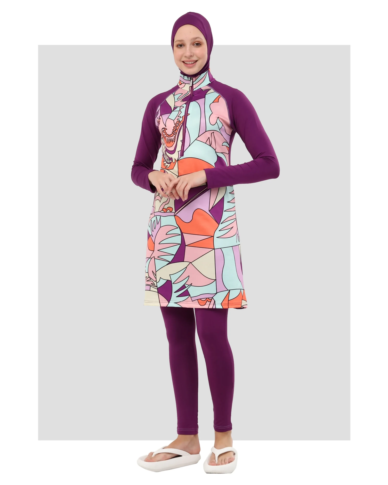 Model in eggplant purple patterned hijab swimwear with long sleeves.