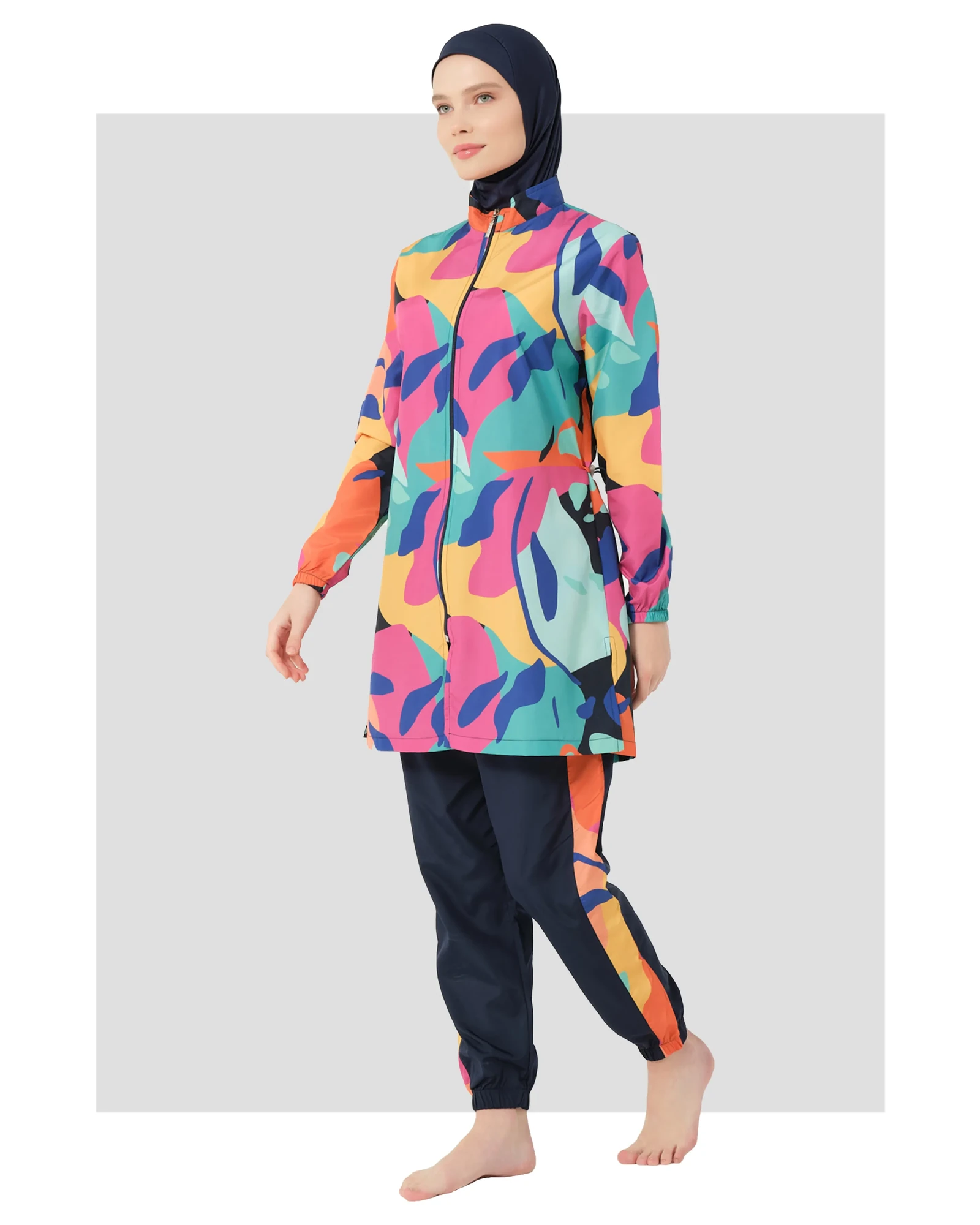 Woman in vibrant abstract print burkini set walking side profile.