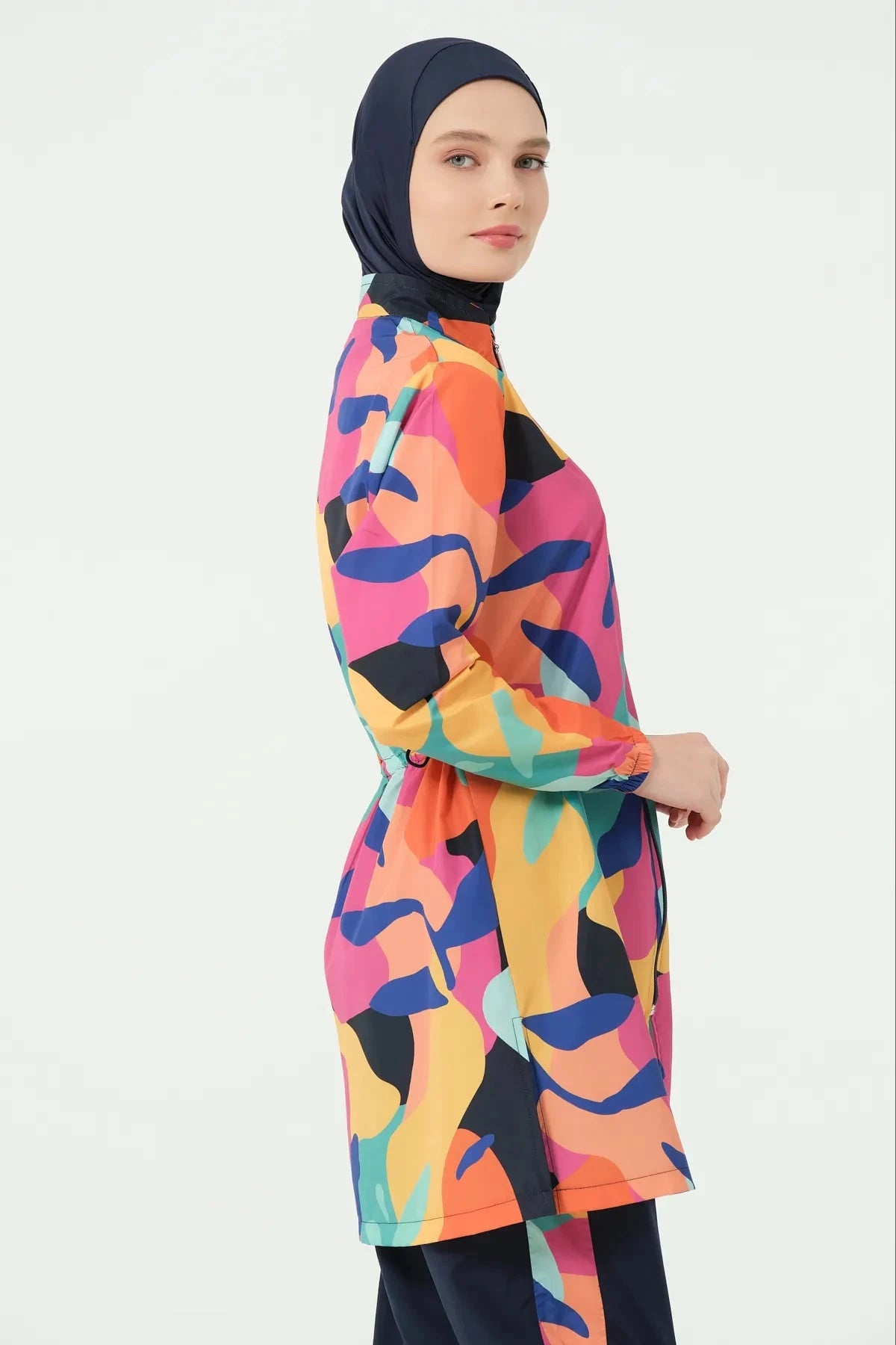 Woman in vibrant abstract print burkini set looking at camera.