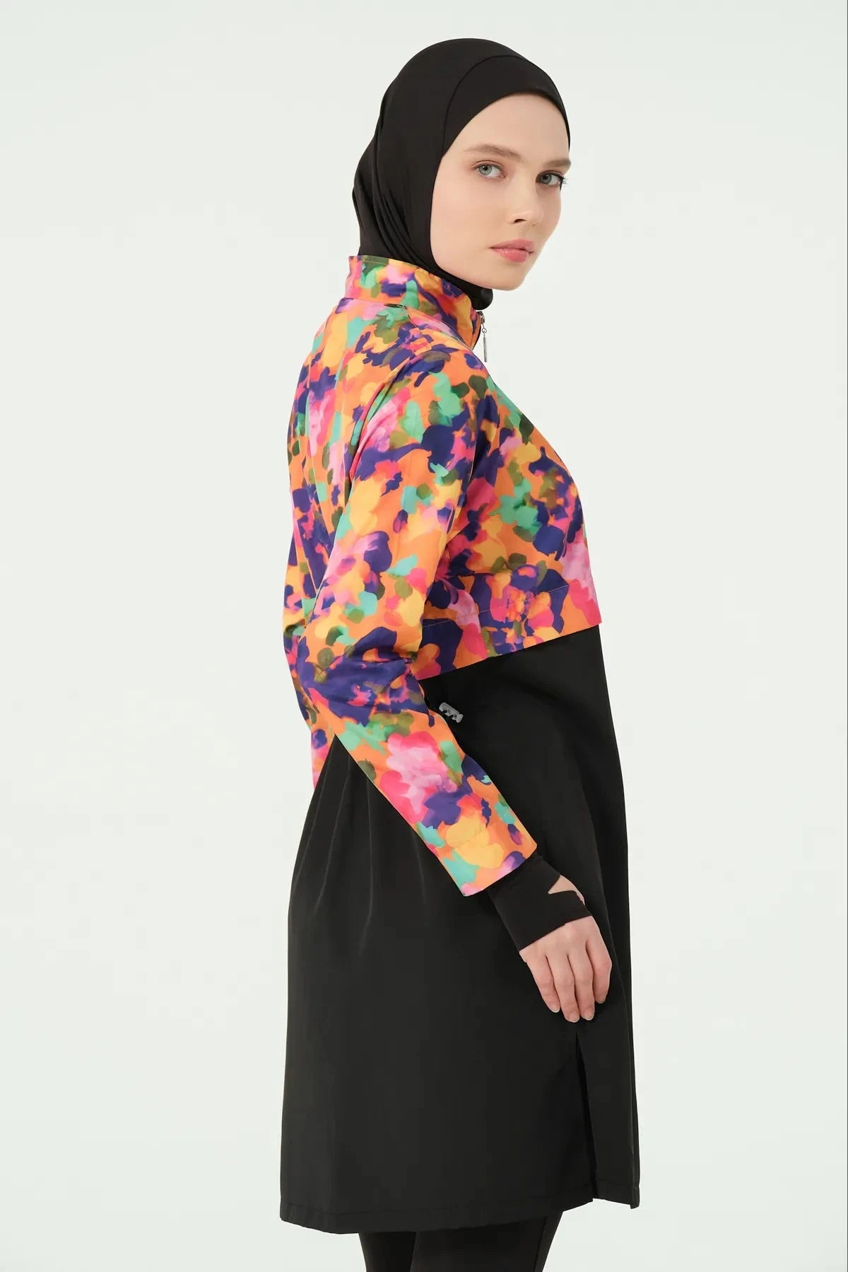 Close-up of woman in black hijab and colorful burkini top.