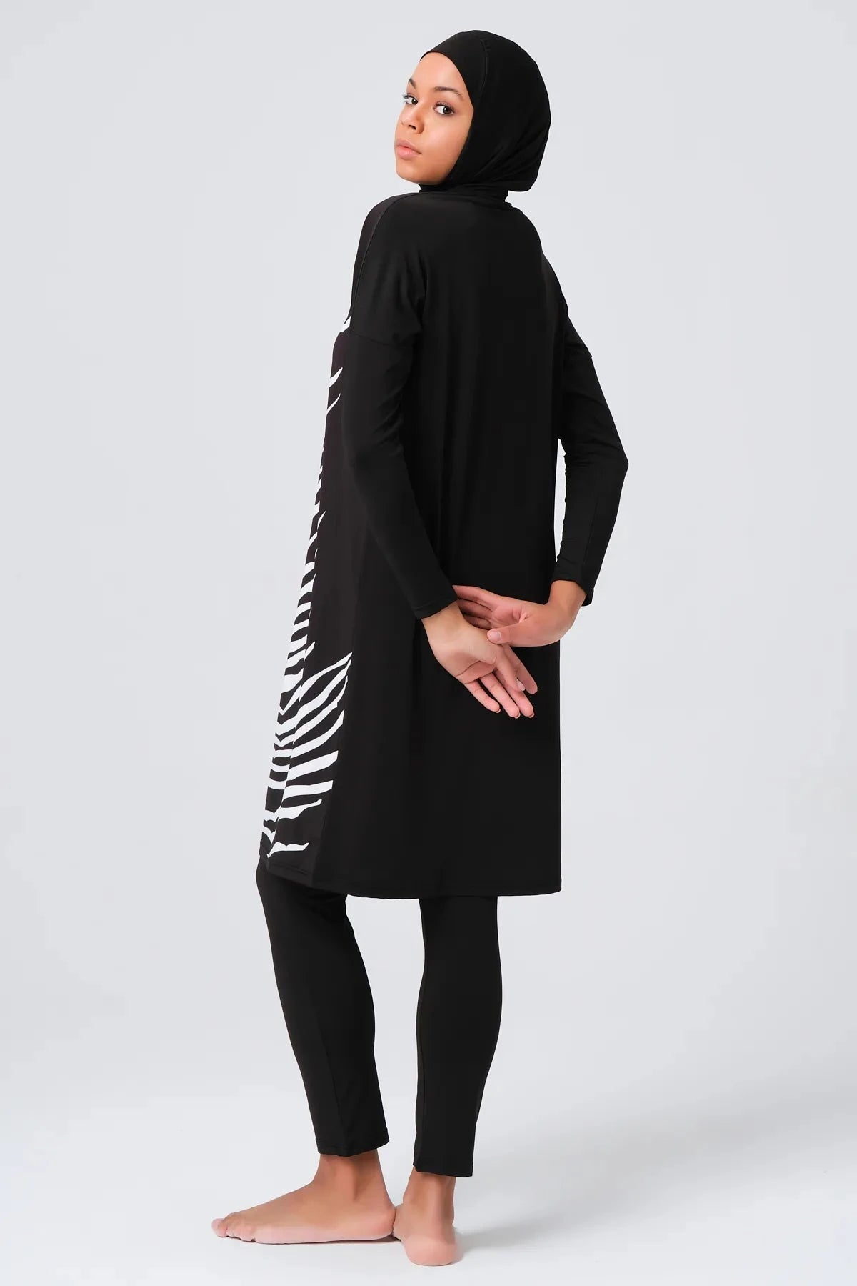 Black modest swimwear set side back view on model.