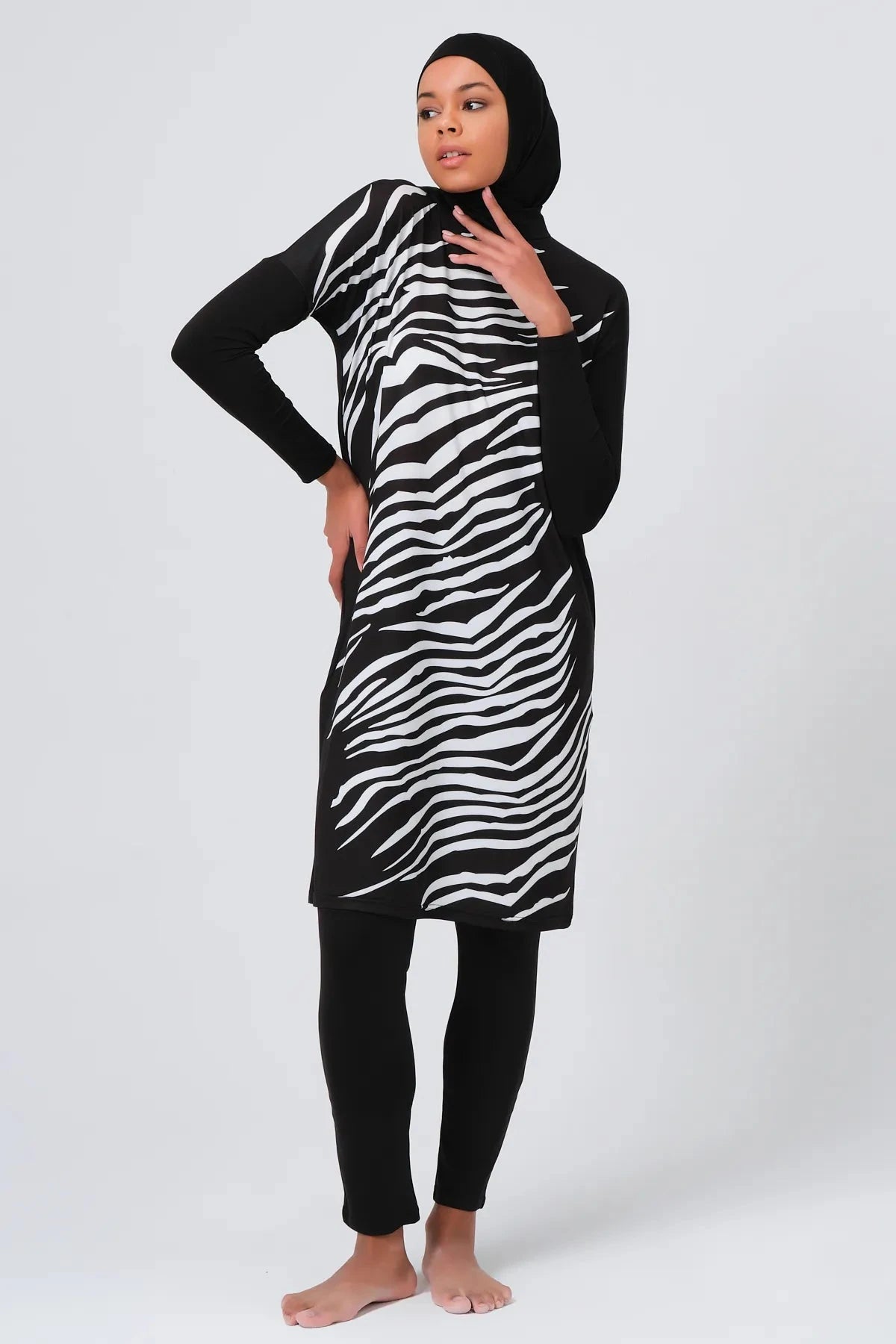 Woman in black and white zebra print burkini posing.