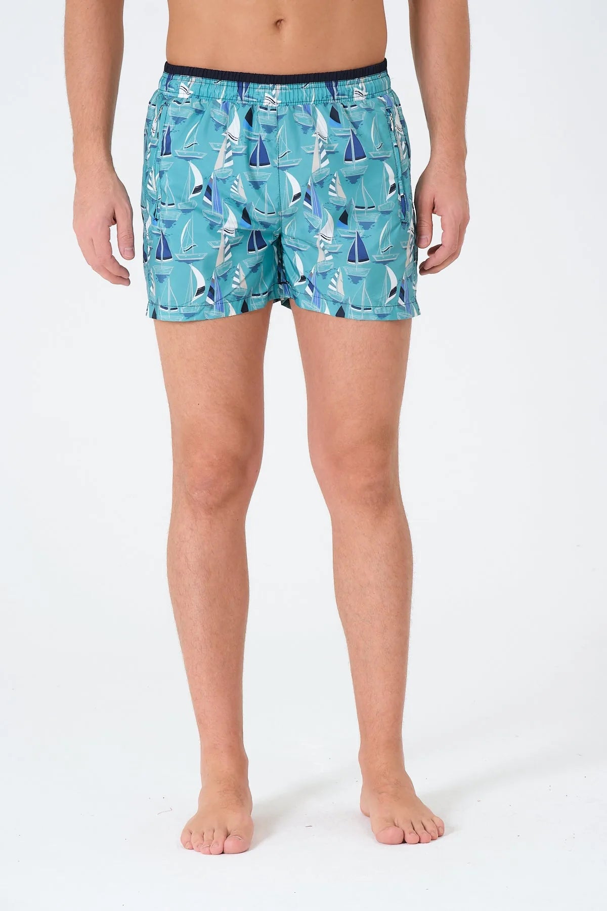 Men's blue and white sailboat print swim trunks, front view.