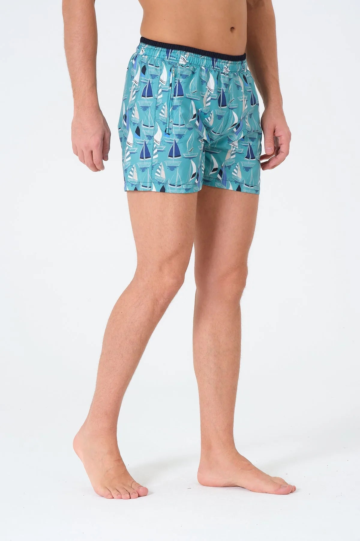 Men's blue and white sailboat print swim trunks, side profile.