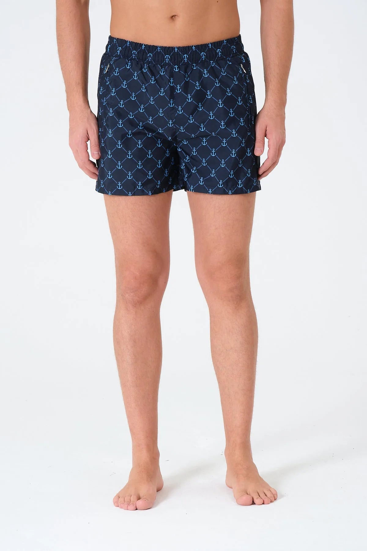 Navy blue men's swim trunks with anchor print, front detail.