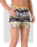 Man wearing tropical print swim trunks, showing front pocket detail.