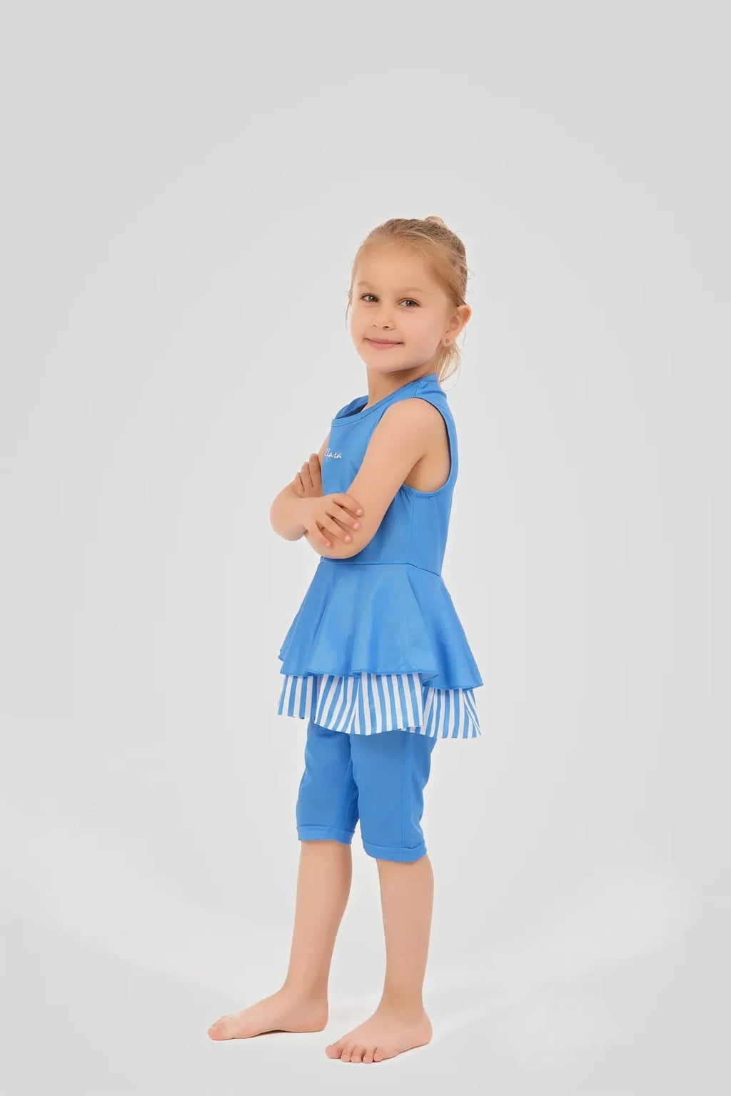 Side view of a girl wearing a blue striped modest swim dress.