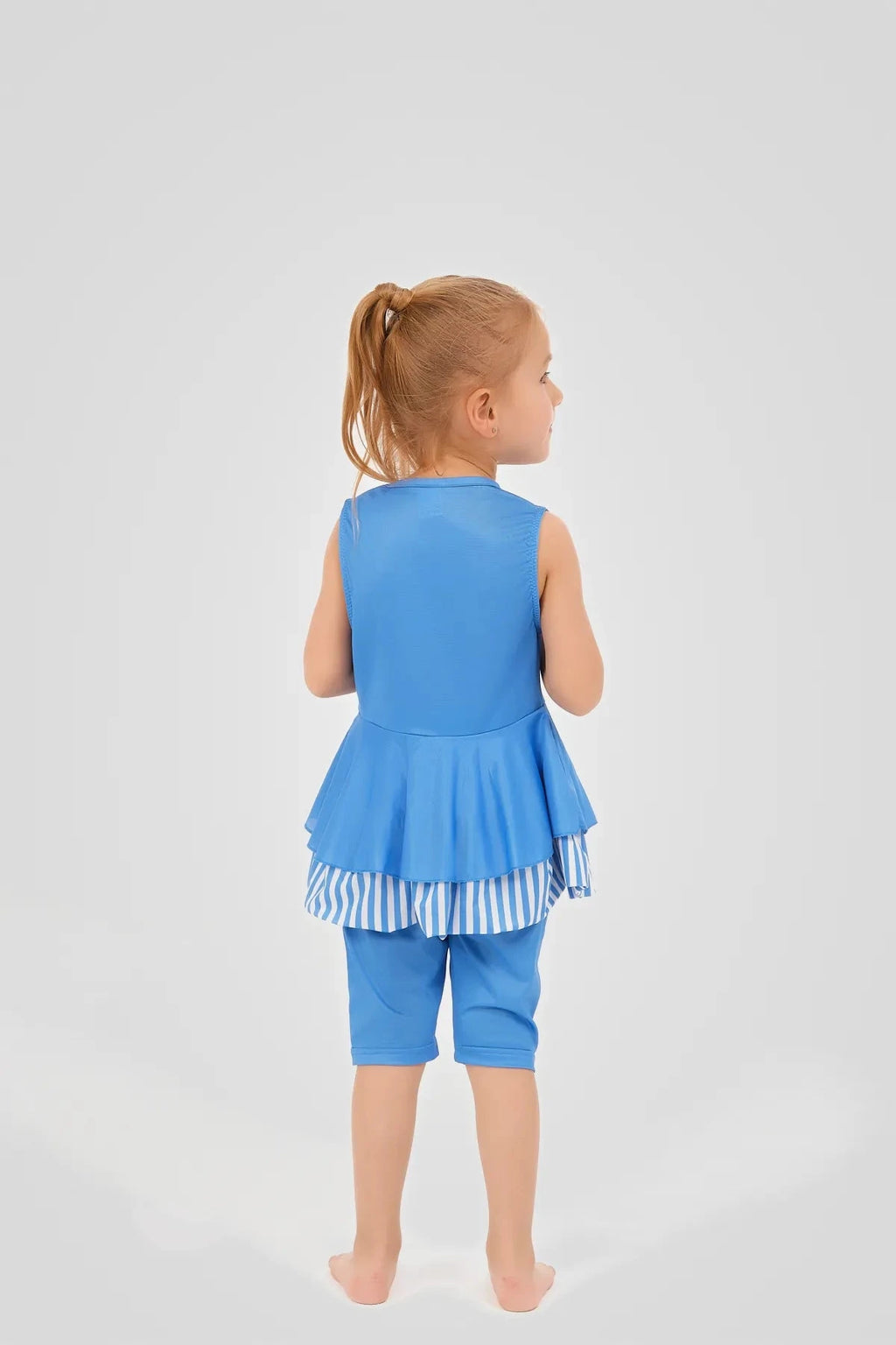Back view of a girl in a blue striped modest swim dress.