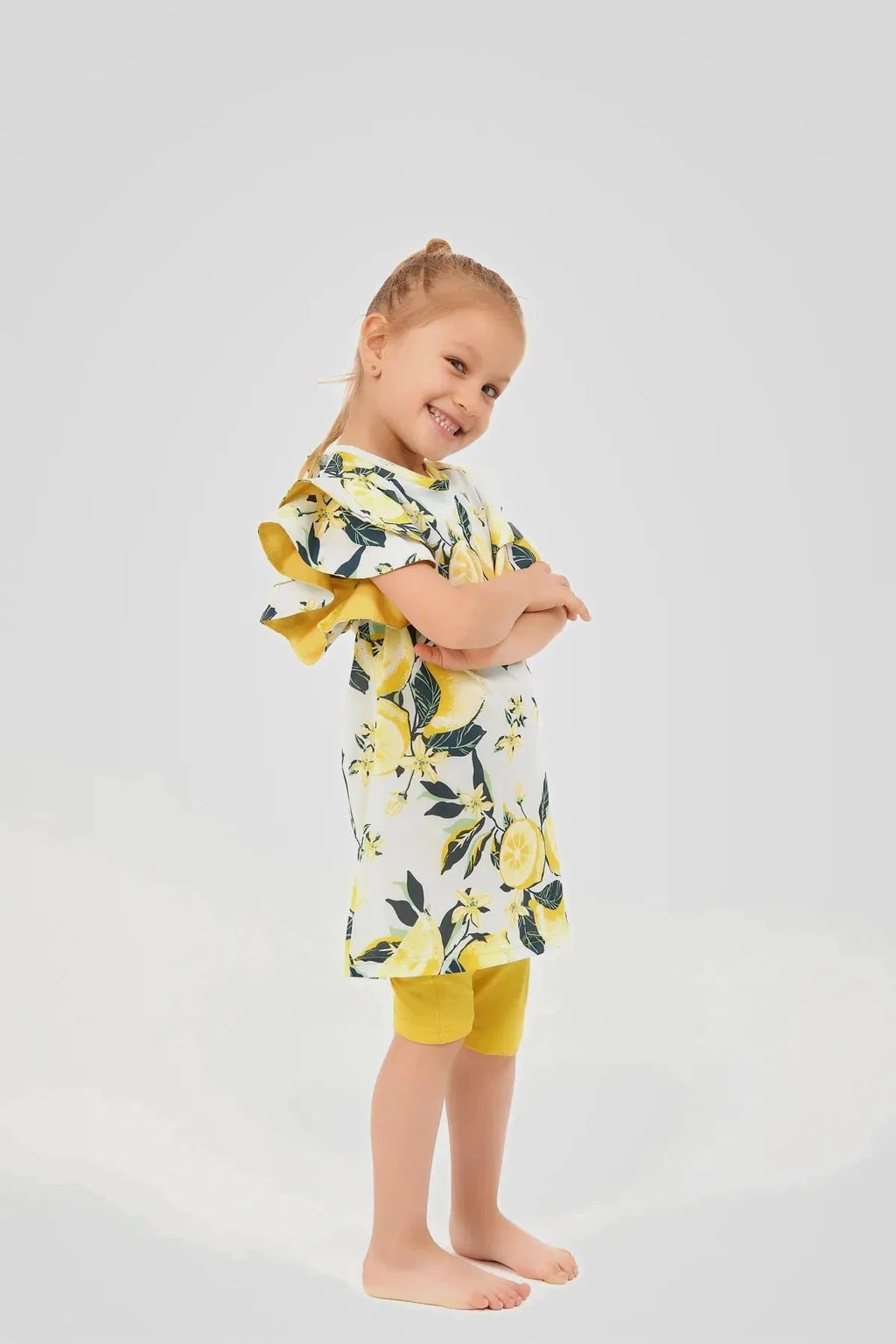 Side view of a girl wearing a lemon print modest swim dress