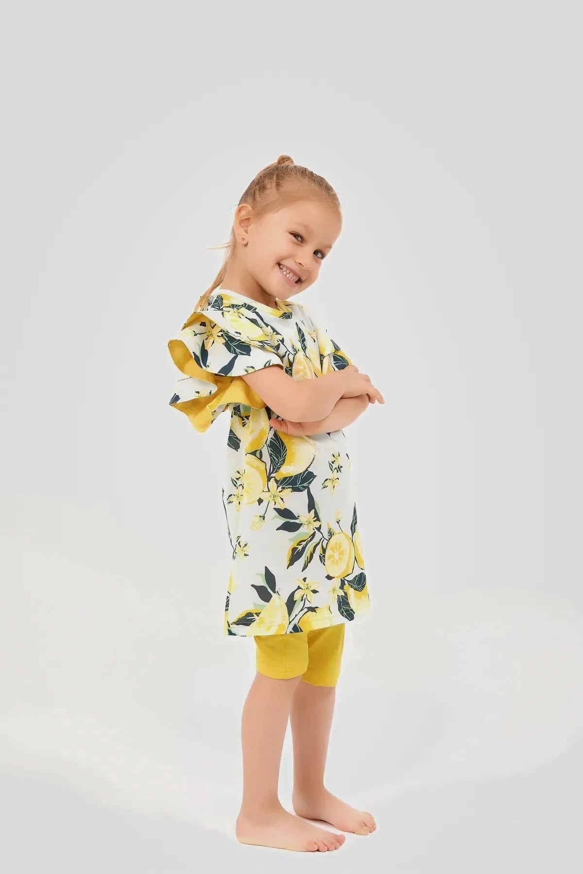 Side view of a girl wearing a lemon print modest swim dress