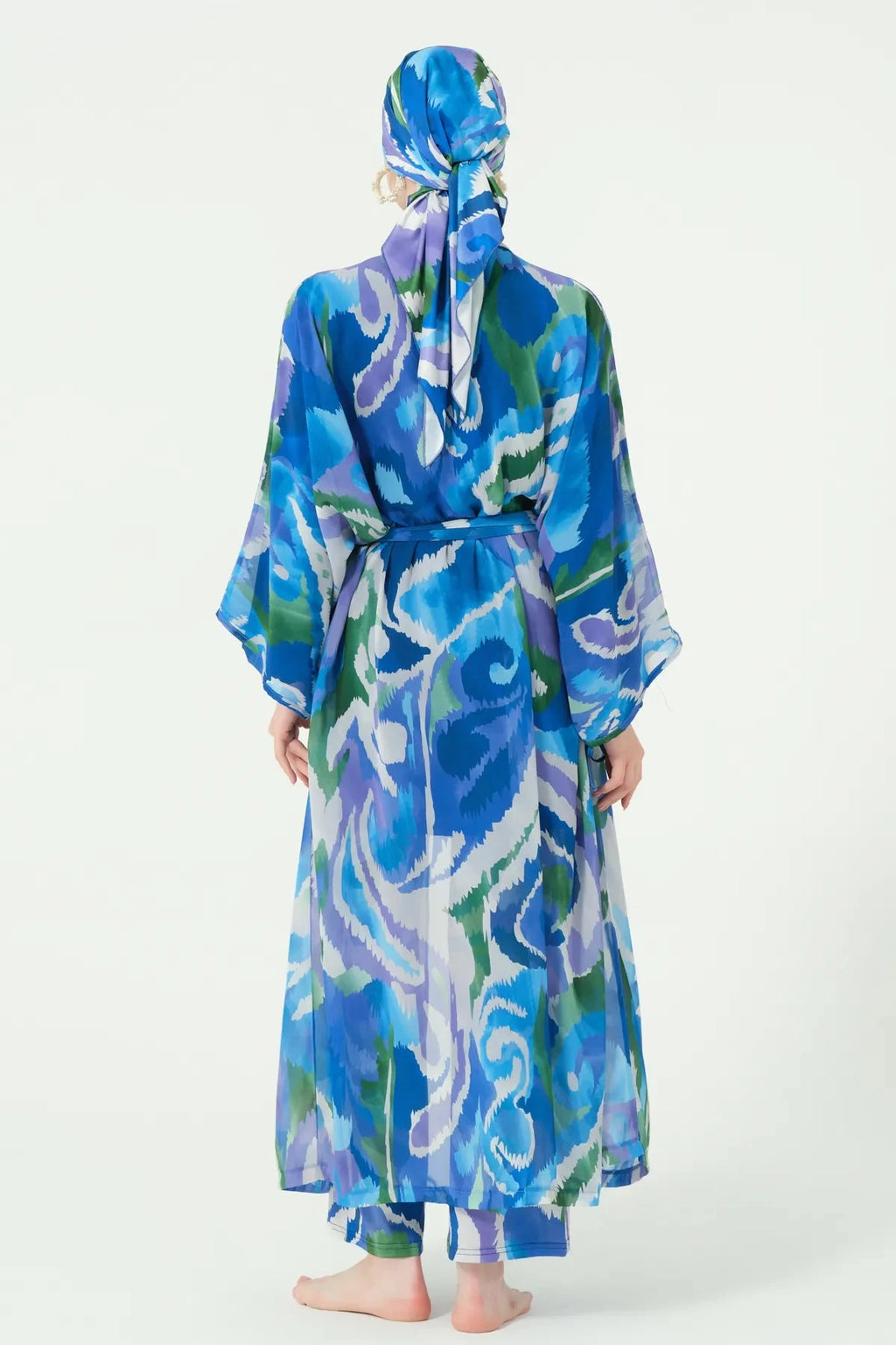 Model in deep azure sheer kimono with abstract print, back view.
