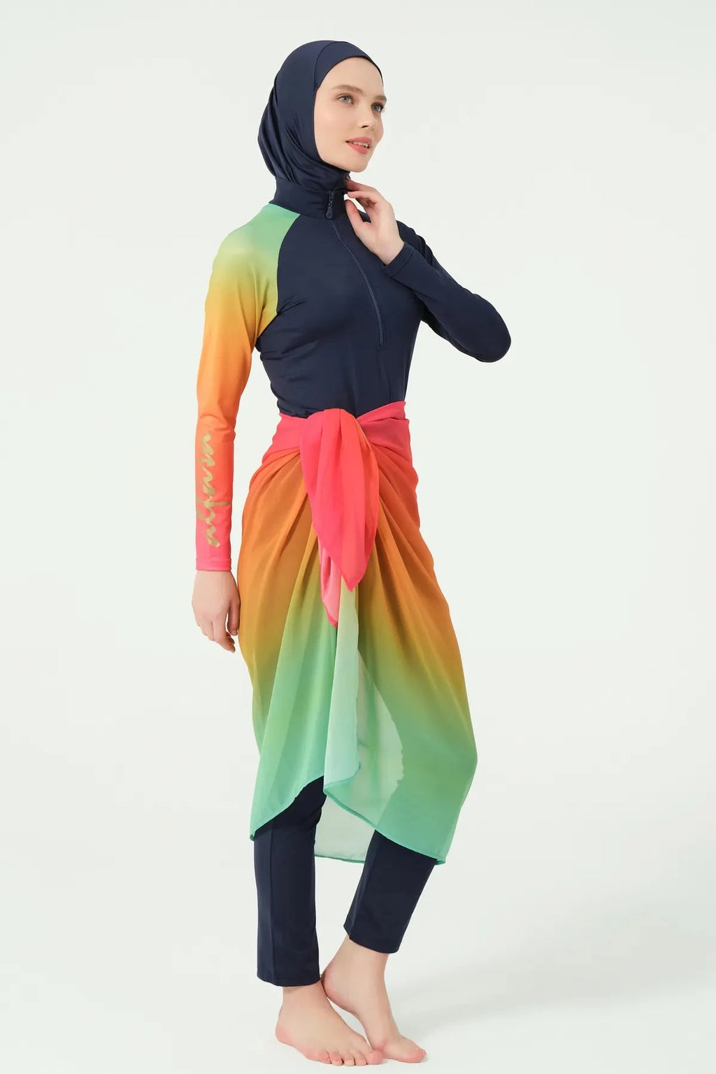 Model in gradient sarong over navy modest swimwear, side pose.
