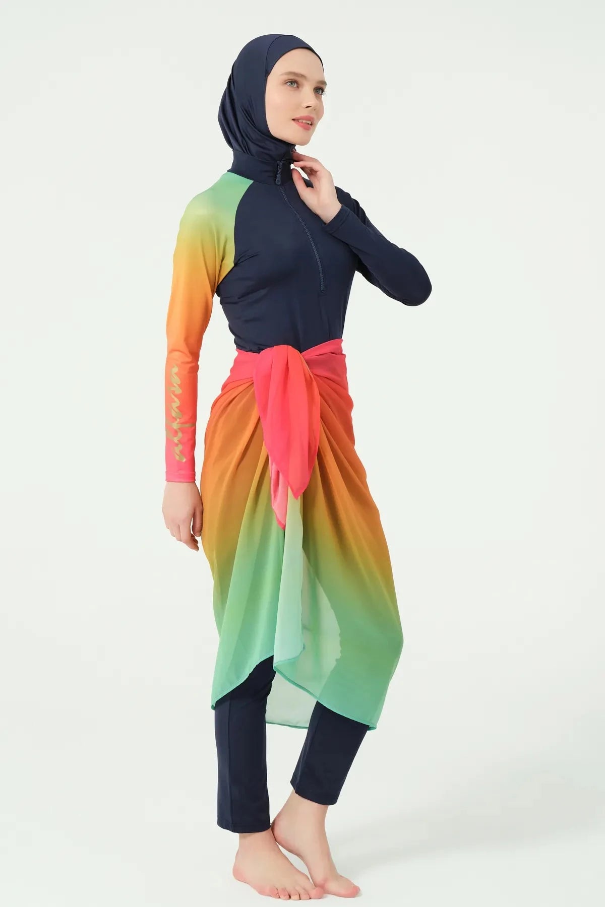 Model in gradient sarong over navy modest swimwear, side pose.