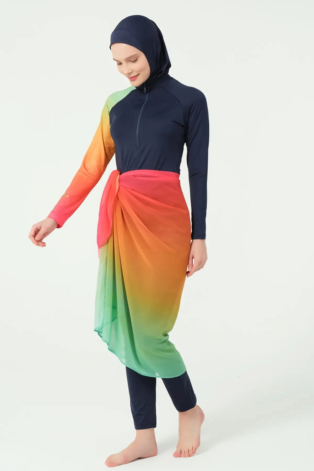 Model in gradient sarong over navy modest swimwear, side walking pose.