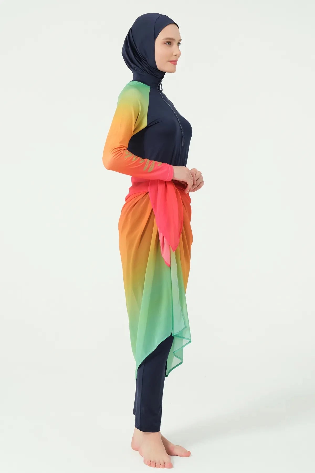 Model in gradient sarong over navy modest swimwear, full profile.