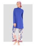 Woman in royal blue modest tunic and nautical print pants with headscarf.