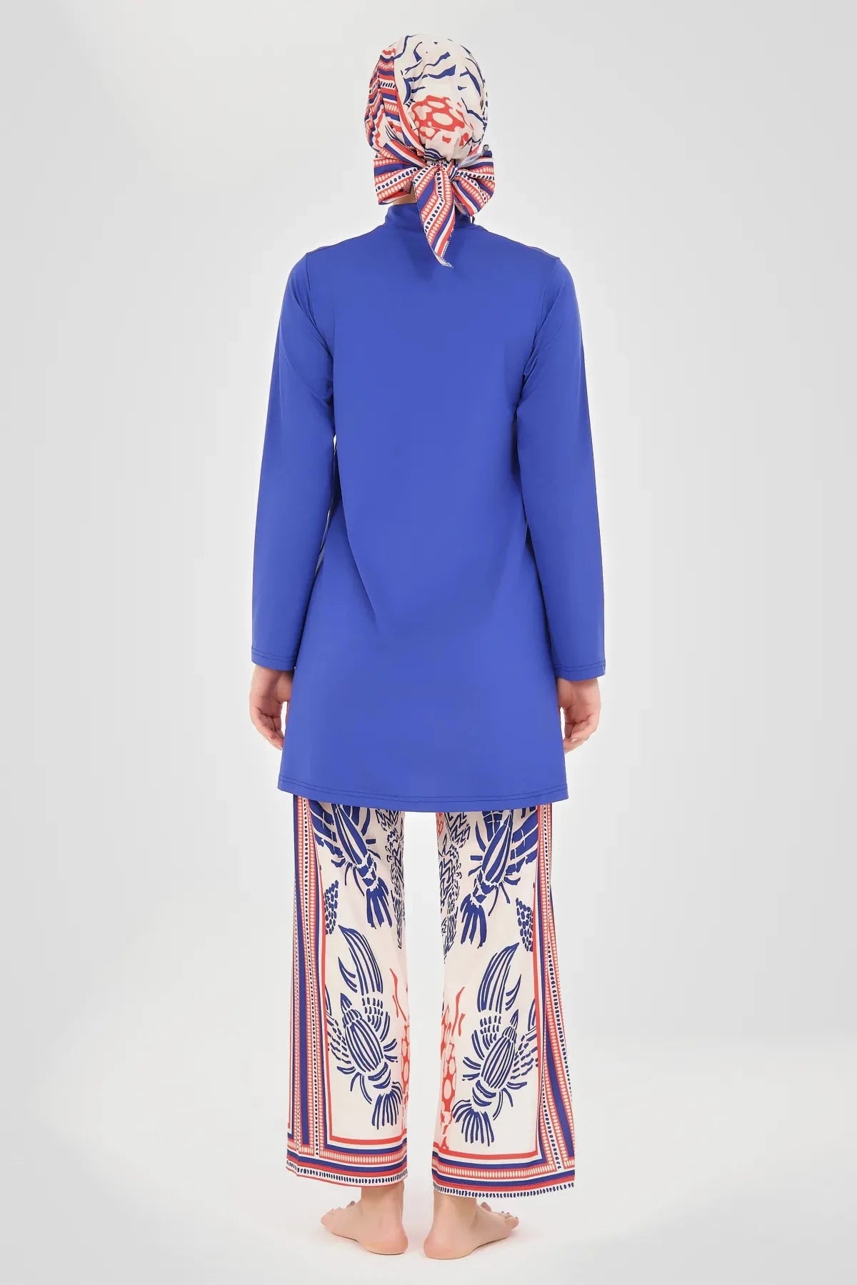 Back view of modest royal blue tunic and nautical print wide-leg pants.